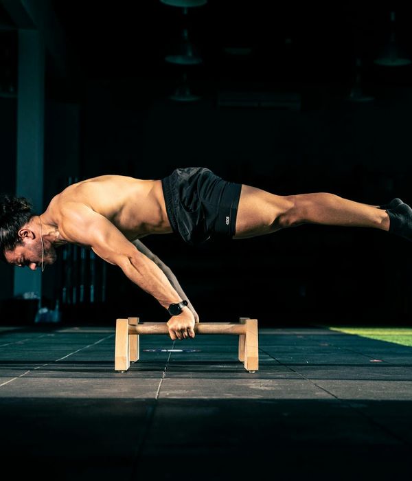 Man performing a controlled strength exercise in a modern gym.